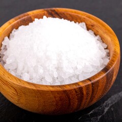 Wooden bowl of white salt crystals