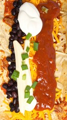 Top View of Open Burrito with Black Beans, Cheese, Sour Cream, Salsa, and Green Onions