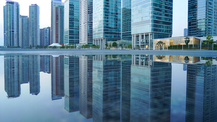 Obraz premium Modern glass skyscrapers reflected in still water at dusk city urban