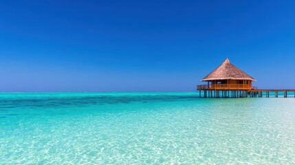 Serene tropical beach with a wooden overwater bungalow under a clear blue sky and turquoise waters