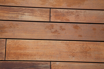 Obraz premium Outdoor ooden walkway surface with natural grain and warm brown tones.