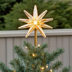 Elegant Golden Star Tree Topper on Christmas Tree Surrounded by Green Pine Branches and Warm Lights