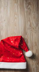 Red Santa hat with gold stars on wood &mdash; festive holiday cap

