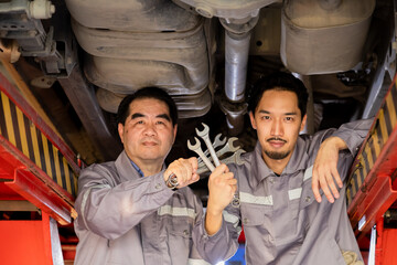 Family business owner, working together inspecting engine, garage small business partnership with generational collaboration, young and senior repair workers highlighting cooperation in auto service