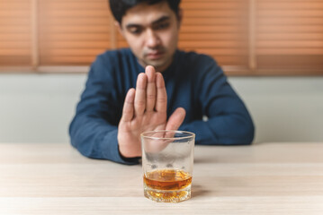 Drunk men deny drinking more glass of whisky by pushing away.