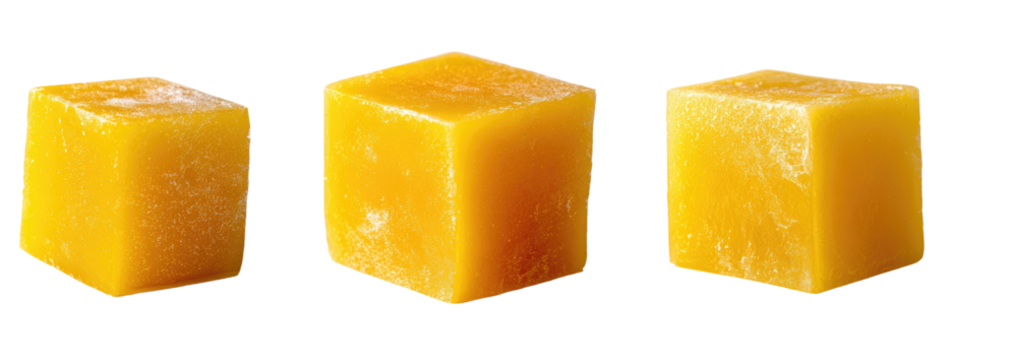 Three bright-yellow, cube-shaped food items