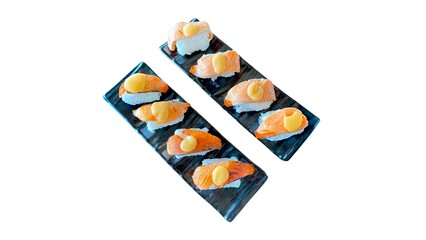 Two black plates of salmon sushi on a white background. Each piece features a slice of salmon and a yellow topping.