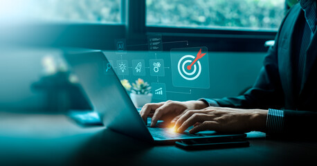 Businessman using laptop with virtual interface showing target icon and strategic planning process, symbolizing digital goal setting, project management, artificial intelligence, and business success