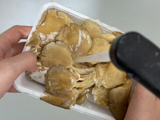 Child rinsing raw mushrooms under water, close-up hands only, unrecognizable, part of cooking series. Salad preparation