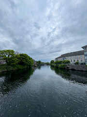 Fototapeta premium Stream in picturesque town with moody sky