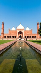 Fototapeta premium Red sandstone mosque, tranquil water feature