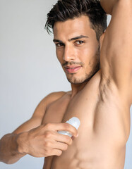 Young male model applying deodorant, close-up underarm shot, clean healthy skin focus, cosmetic advertising style