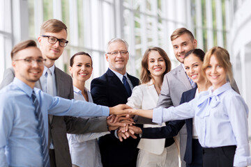 happy business people stacking hands at office