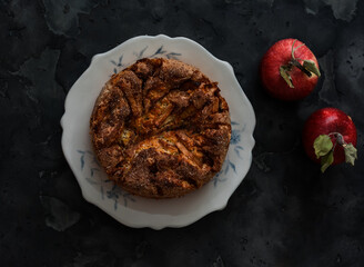 Charlotte pie with apples and cinnamon is a seasonal dessert on a dark background, top view