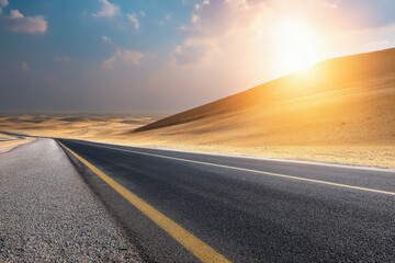 Naklejka premium Empty asphalt road winding through a vast desert landscape at sunset, with a towering sand dune rising majestically on the right