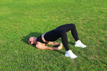 Fototapeta premium Athletic woman trains on outdoor stadium in summer day. Fitness workout.