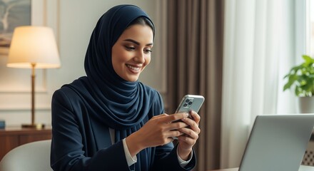 Smiling woman in hijab using smartphone indoors