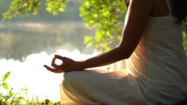 Person, hands and meditation on lake in sunset for spiritual wellness, inner peace or outdoor zen. Closeup of yogi in meditate, exercise or yoga for health, awareness or chakra by the ocean coast