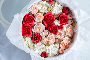 Beautiful arrangement of marshmallow flowers in a white round box, featuring vibrant red, soft pink, and delicate white blooms, showcasing unique floristry concept with copy space