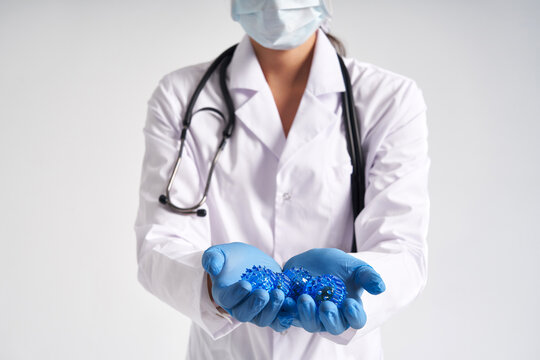 Doctor holding in hands wearing medical gloves three-dimensional blue model of virus - coronavirus COVID-19