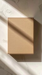 Plain Brown Cardboard Rectangular Box with Lid on Textured Light Gray Surface with Shadow