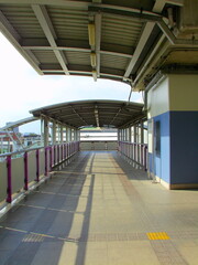 An empty train platform with structural beams and roof cover, captured in a retro film grain aesthetic with vintage tones.