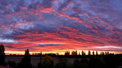 Obraz premium angle. Dramatic sunrise and sunset sky with vibrant clouds, showcasing warm and cool color contrasts in a panoramic view. inspiring travel planning.