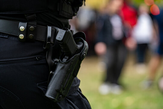 Close up of police handgun in holster on duty belt.
