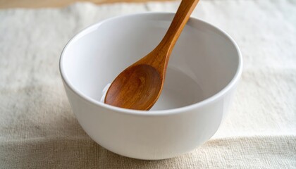 Empty White Bowl with Wooden Spoon on Neutral Background