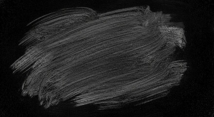 Obraz premium A close-up shot of a chalk smudge on a black surface, showing textured brush strokes.