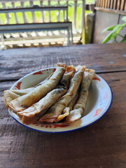 Serving chocolate bananas on an antique iron plate, on a wooden table, menu in a cafe with an outdoor concept.