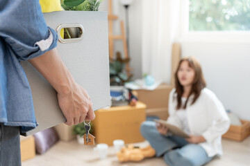 Moving house, relocation. Couple help set and move furniture for new apartment, inside the room was...