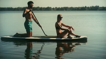 Relaxing aquatic activity . Enjoying water sports . Paddlers on stand-up paddleboard