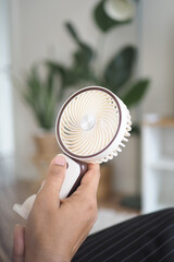 Handheld fan offers cool relief on a hot day indoors