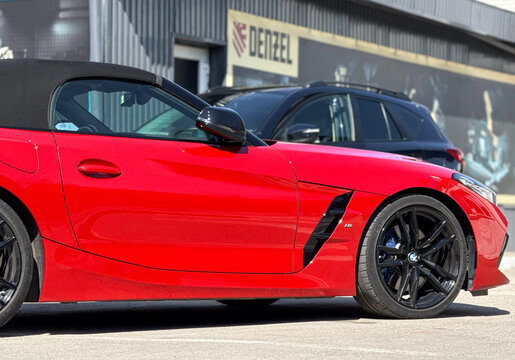 BMW Z4 M40i III (G29) red color parked on street. Exterior of red BMW Z4 M40i III (G29) sport coupe manufactured by the German automobile manufacturer on parking lot.
