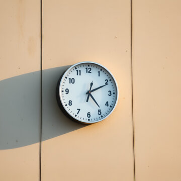 wall clock on the  concrete wall at 4pm with sunlight on the right hand side