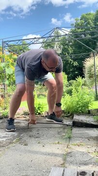 Mann arbeitet auf einer Terrasse im Garten
