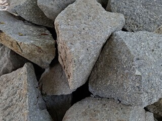 ​A close-up shot of a pile of large, textured, gray rocks with jagged edges.