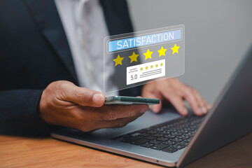Businessman using smartphone and laptop with customer satisfaction rating five stars, concept of service quality, client feedback, online review, user experience and customer support.