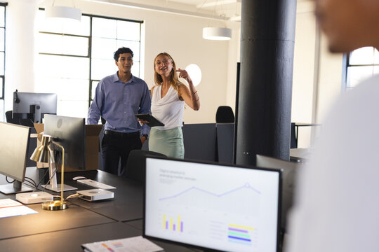 Discussing data analysis, business professionals collaborating in modern office setting - Powered by Adobe