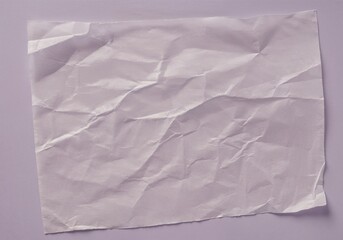 Obraz premium Wrinkled tracing paper sheet on purple background