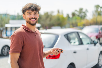 Young Arabian handsome man at outdoors holding car keys with happy expression