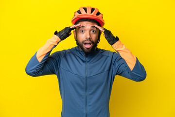 Young cyclist Brazilian man isolated on yellow background with surprise expression