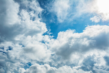 Fototapeta premium White fluffy clouds scattered across a deep blue sky creating a bright and airy weather background with natural light