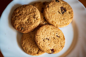 Healthy whole grain cookies with dried fruit on a white plate