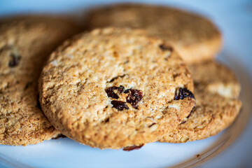 Healthy whole grain cookies with dried fruit on a white plate
