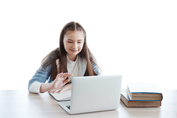 Smiling Caucasian girl learning online with laptop and chatting with people in classroom of school. Education cancept