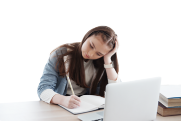 Serious Caucasian girl learning online with laptop and writing homework on notebook in classroom of school. Education cancept
