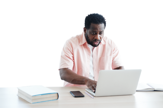 African American businessman surprised and working with laptop on desk