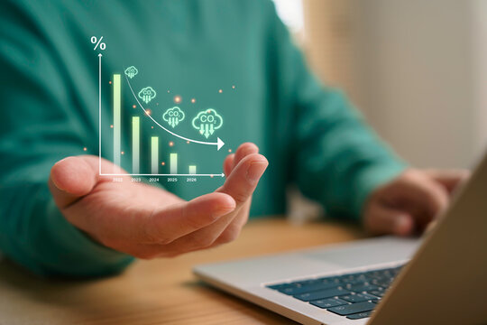 Businessman presenting carbon emission reduction graph which CO2 decline trend for climate change strategy and sustainable green energy plan of environmental protection and net zero future.